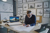 An architect sitting in his office designing a glamping pod for his client. He magically turns the glamping pod from a drawing into a real life pod.